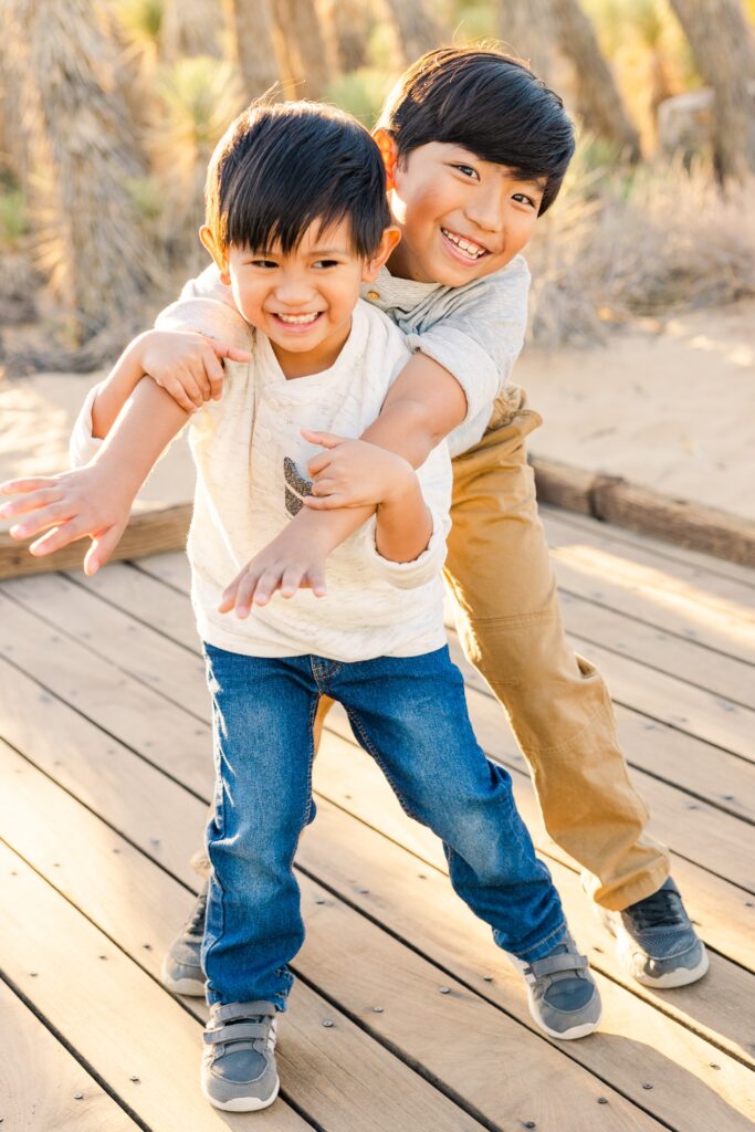 Two happy brothers smiling and playing during family photoshoot in Lancaster, California