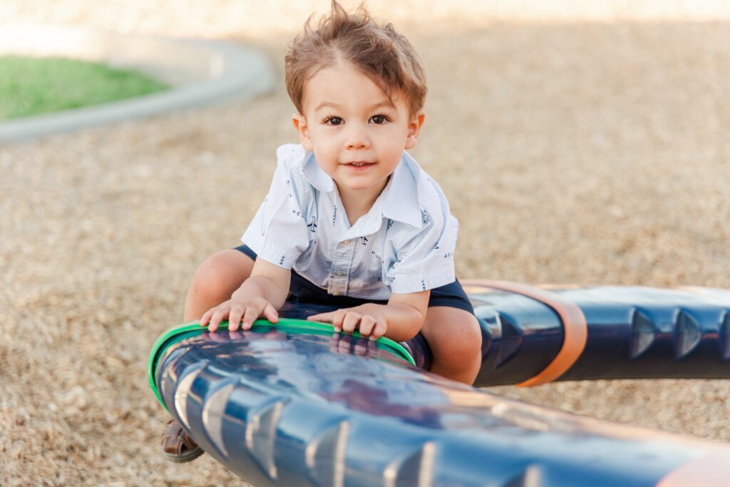 Boy smiling for family photoshoot on playground in Lancaster, California