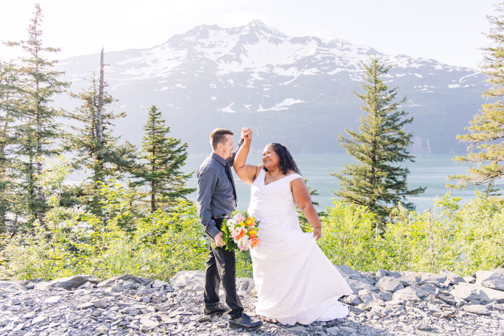 Couple dancing at elopement in front of lake, mountain, and glacier waterfalls in Whittier, Alaska