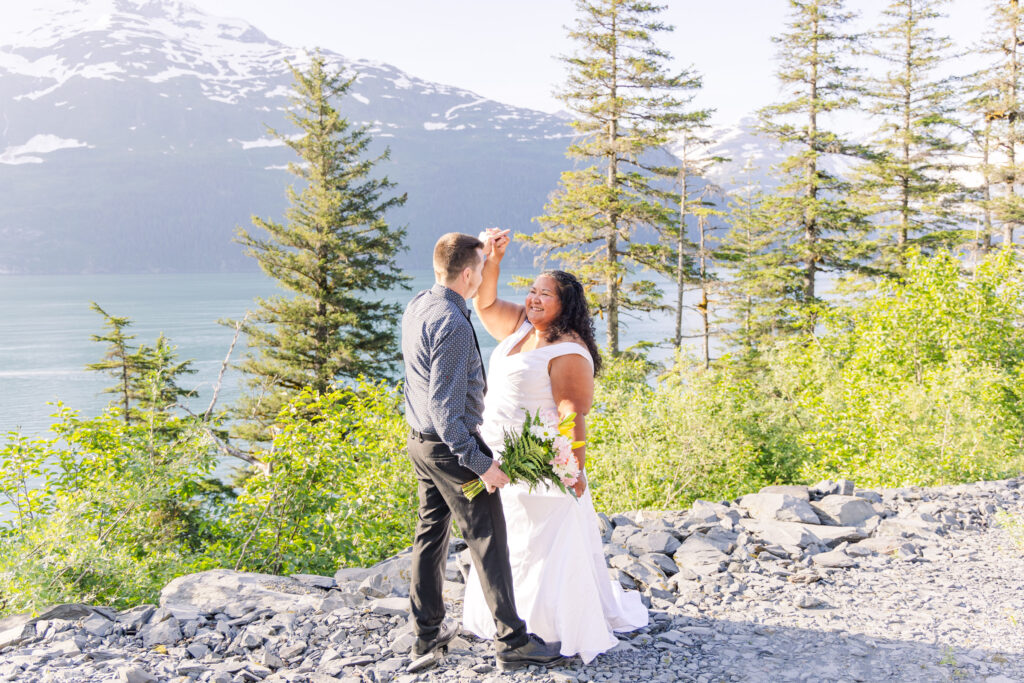 Couple dancing at elopement in front of lake, mountain, and glacier waterfalls in Whittier, Alaska