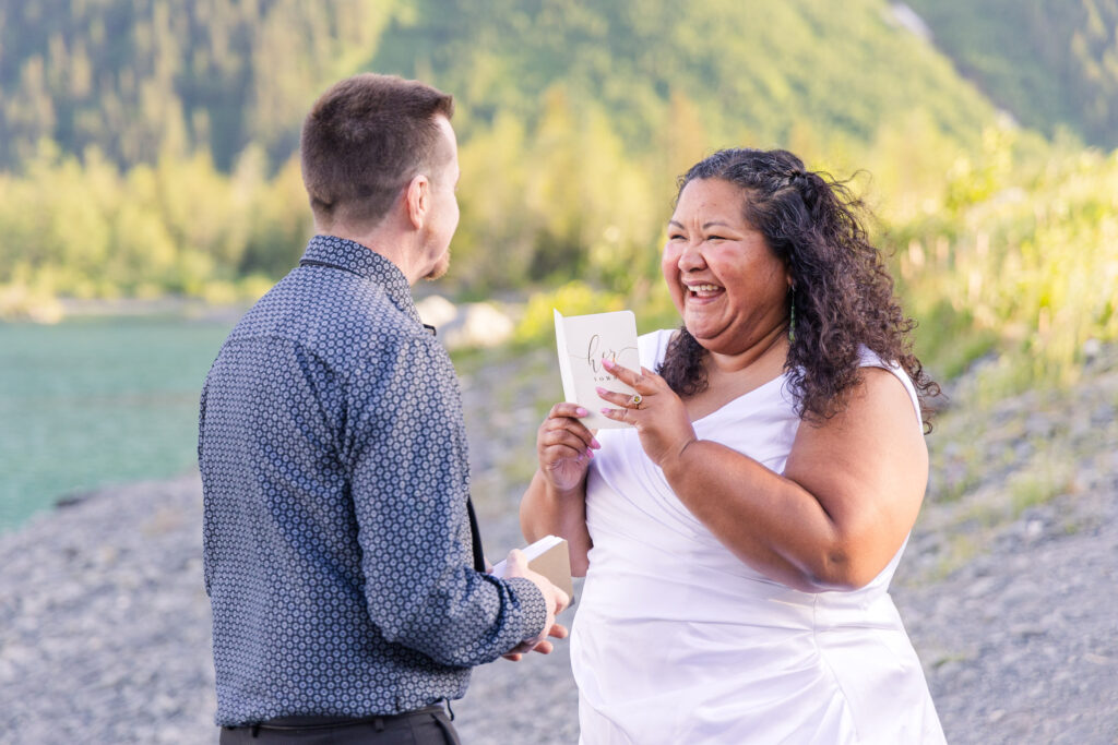 Couple exchanging wedding vows at scenic elopement in front of glacier, mountain, and lake in Whittier, Alaska