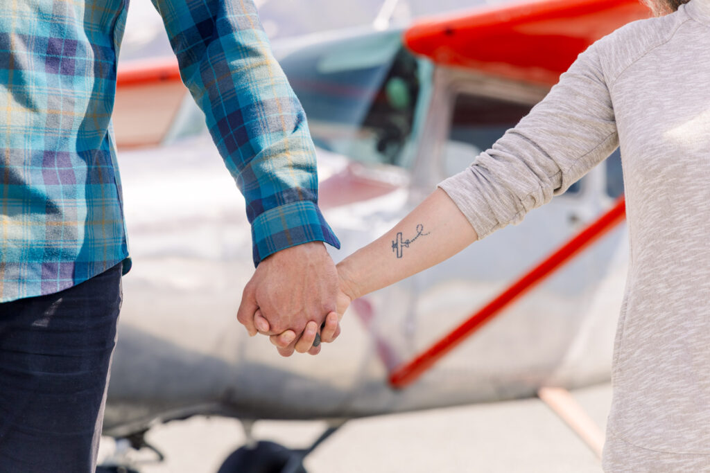 Close-up detail of an airplane tattoo, with a Cessna 172 airplane out of focus in the background