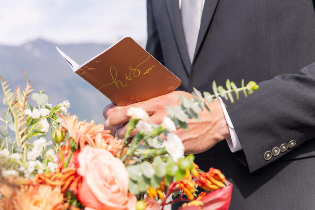 Close-up detail of groom's vow book during Alaskan elopement ceremony