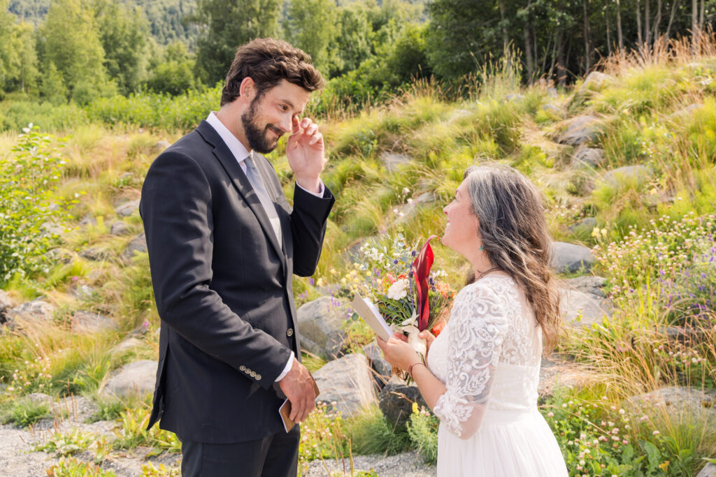 Groom wiping tears from eye during emotional intimate Alaskan elopement ceremony