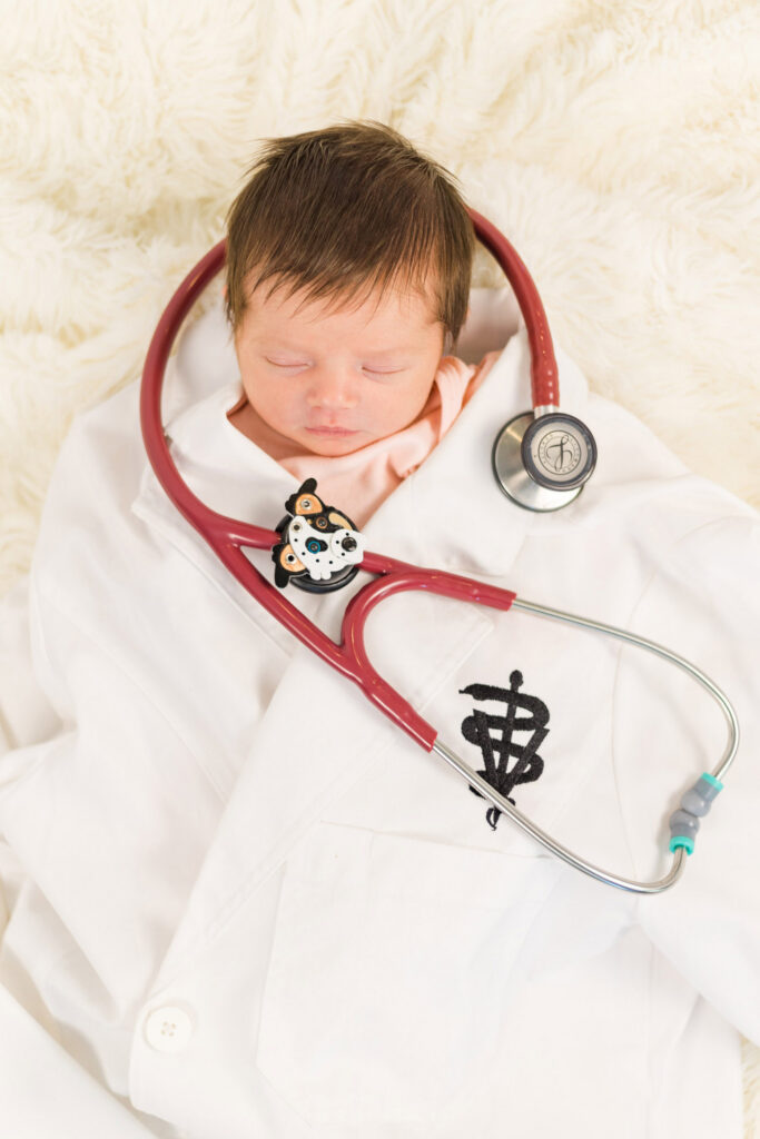 newborn in veterinarian doctor jacket with stethoscope in studio session