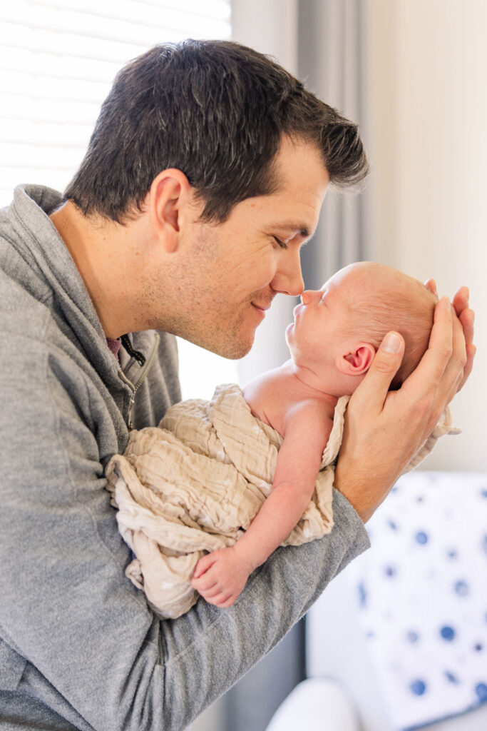 father touching noses with newborn baby during lifestyle newborn session