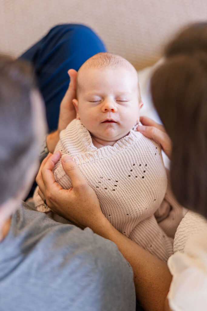 parents looking down at newborn baby they are holding during lifestyle newborn session