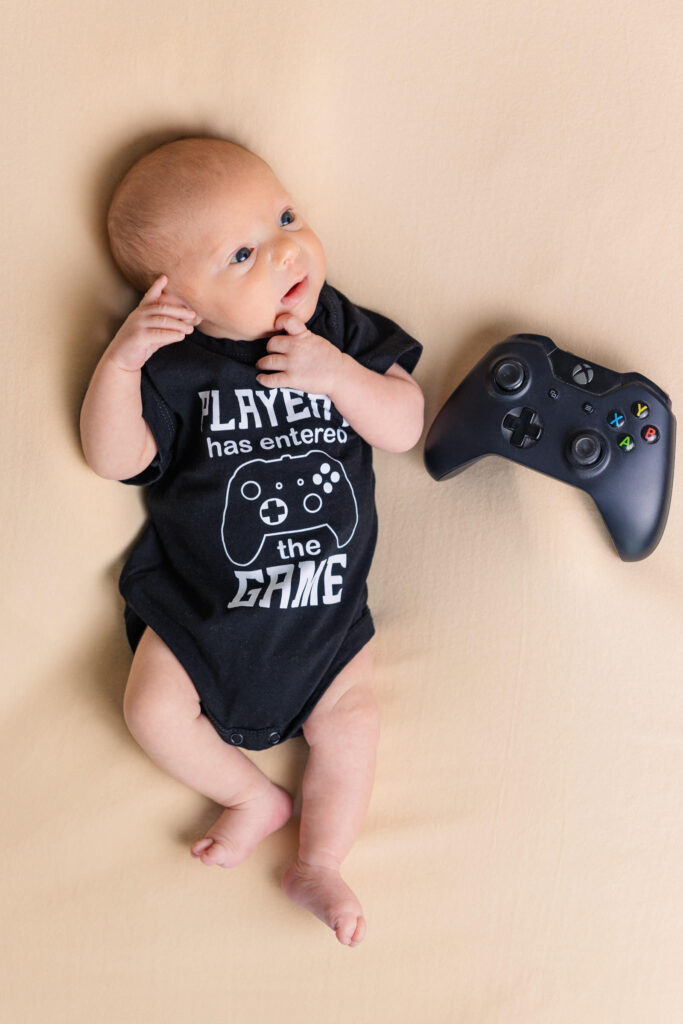 video game themed newborn session with baby and controller