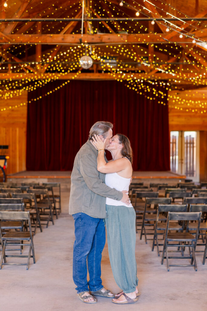 Newly engaged couple kissing inside the Pioneertown Soundstage.