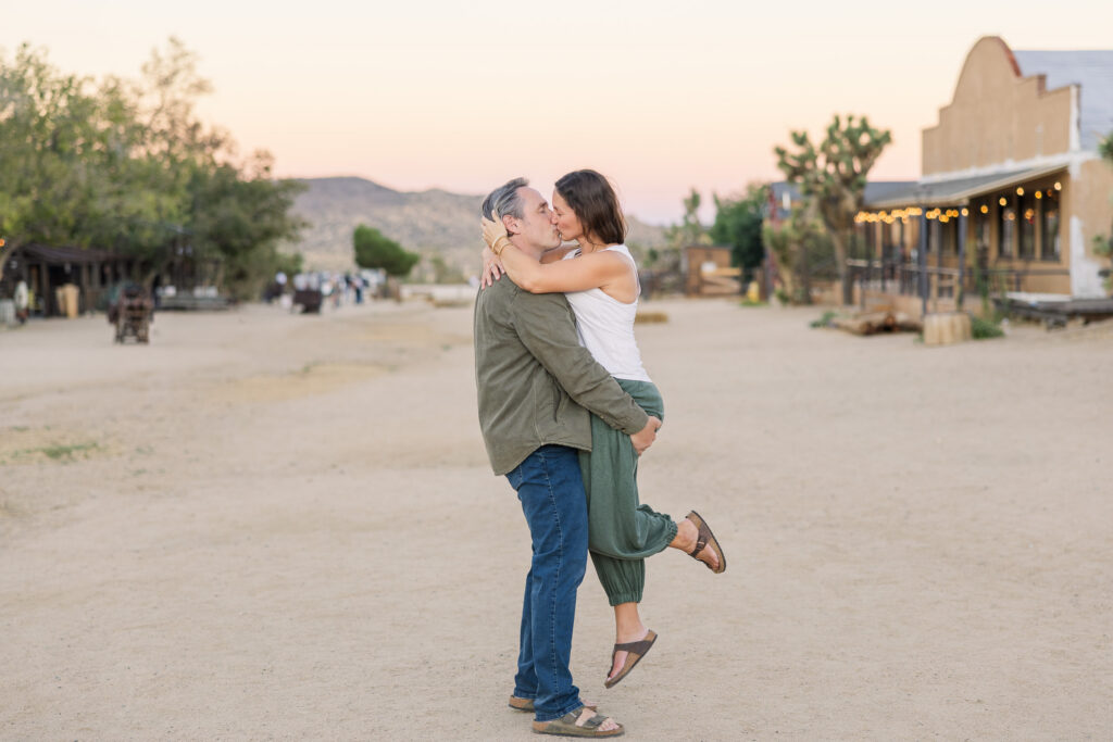 David lifts Lisa into a kiss on Mane Street, surrounded by the Western storefronts of Pioneertown.